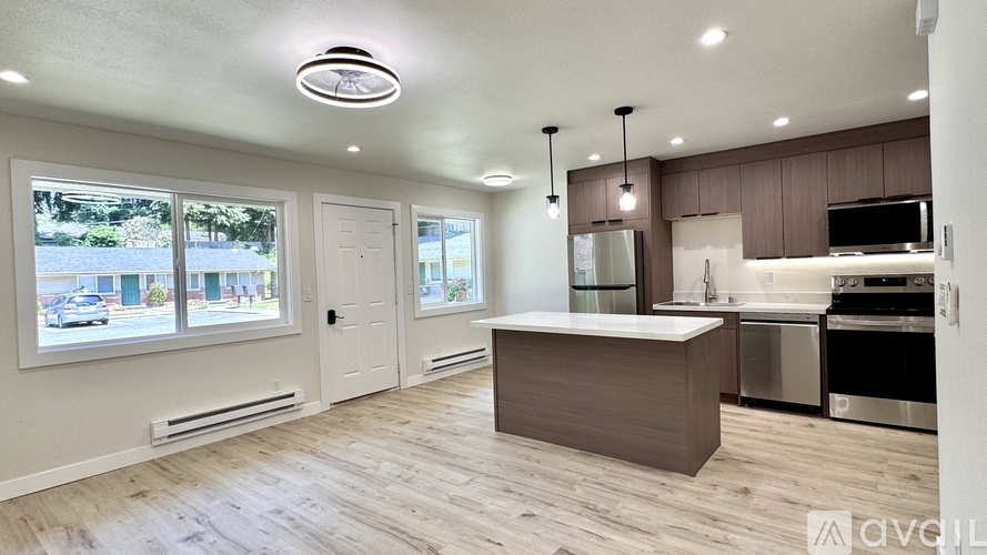 A modern kitchen with a wooden floor and stainless steel appliances.