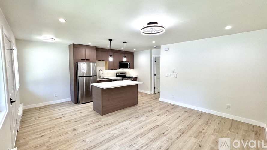 A kitchen with a refrigerator, microwave, and oven is available for rent.