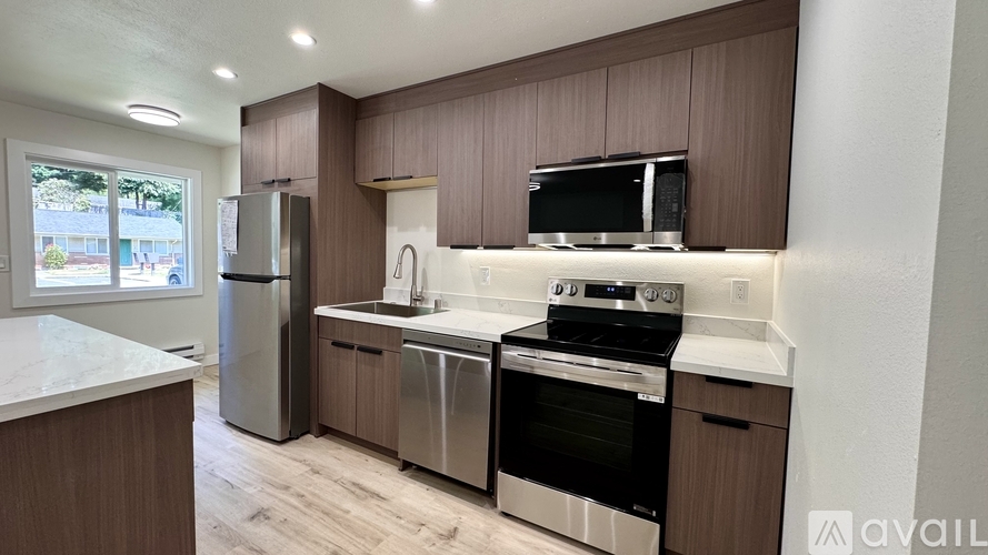A kitchen with brown cabinets and stainless steel appliances.