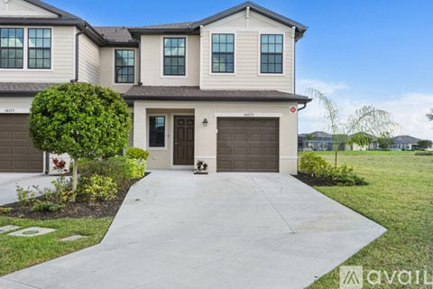 A two-story house with a garage and a driveway.