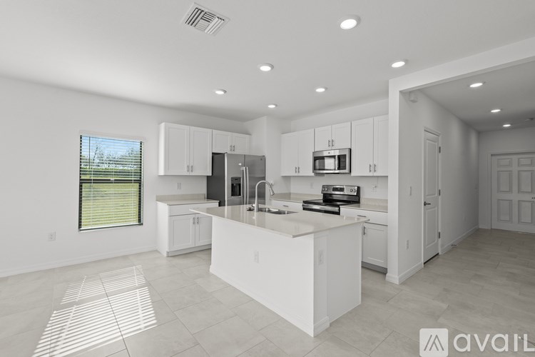 A modern kitchen with white cabinets and appliances.