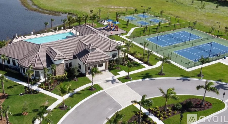 A large house with a pool and tennis courts.