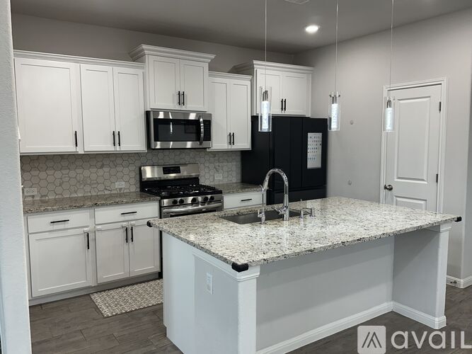A kitchen with white cabinets and a granite countertop.