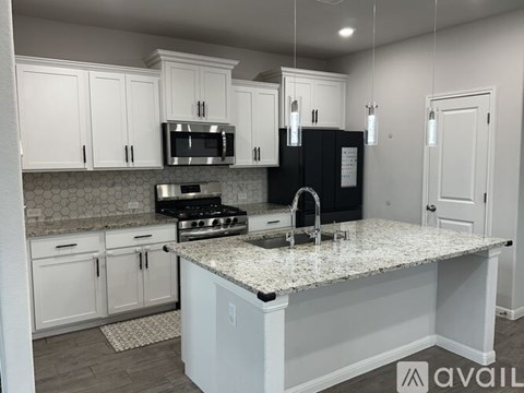 A kitchen with white cabinets and a granite countertop.