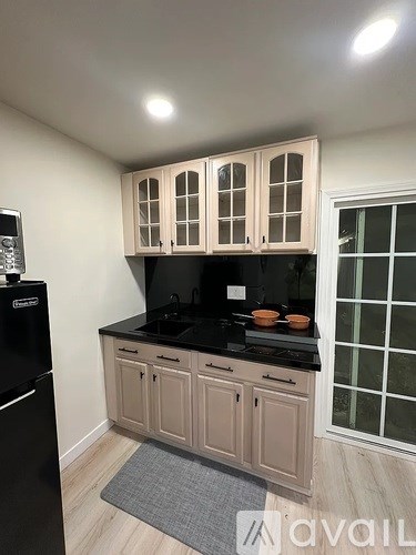 A kitchen with wooden cabinets and black countertops.
