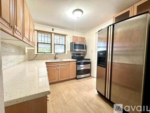 A kitchen with wooden cabinets and a refrigerator.