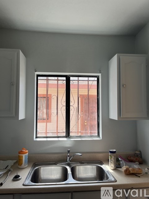A kitchen with a double sink and a window with bars.