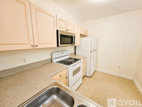A kitchen with a sink, stove, and refrigerator.