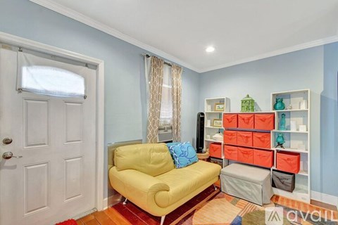 A living room with a yellow couch and a white door.