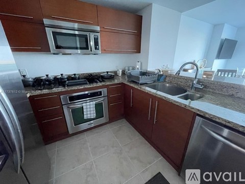 A kitchen with brown cabinets and a stainless steel sink.