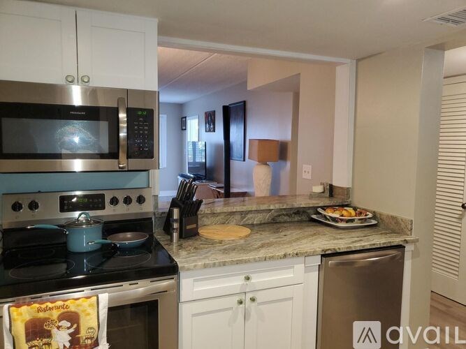 A kitchen with a stove, microwave, and a counter with food on it.
