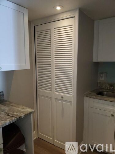 A kitchen with a white cabinet and a sink.