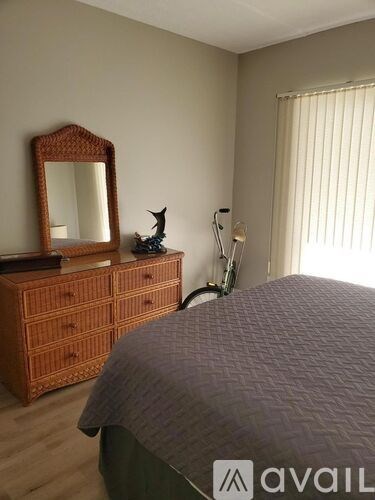A bedroom with a bed, a dresser, and a mirror.