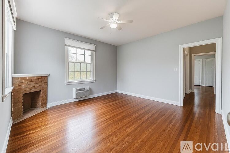 A room with a fireplace and wood flooring.