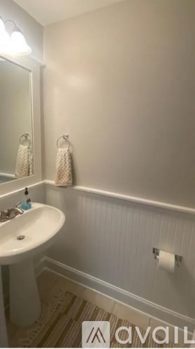 A white bathroom with a sink and a mirror.
