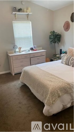 A bedroom with a bed, dresser, and window.