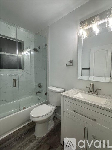 A bathroom with a toilet, sink, and mirror.