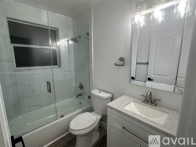 A bathroom with a toilet, sink, and shower.