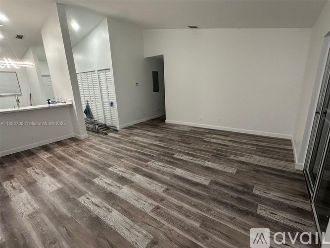A room with wooden flooring and white walls is available for rent.
