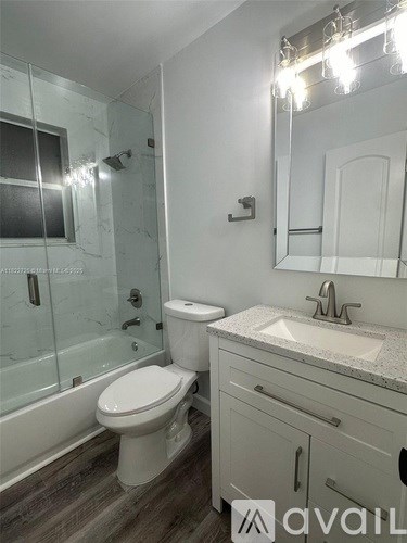 A bathroom with a toilet, sink, and mirror.