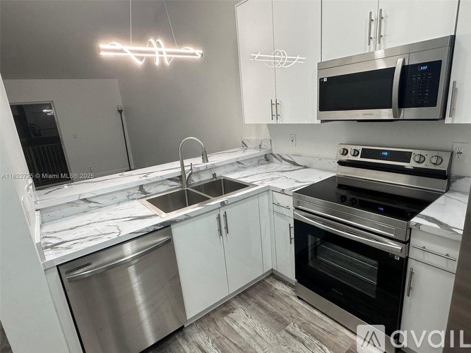 A modern kitchen with stainless steel appliances and white cabinets.