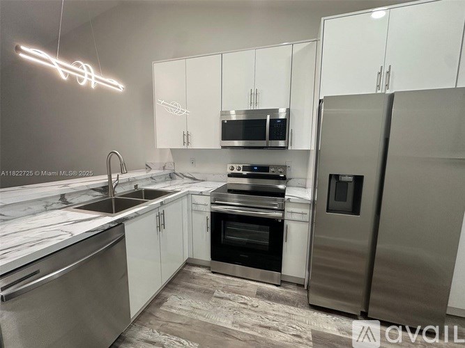 A modern kitchen with stainless steel appliances and white cabinets.