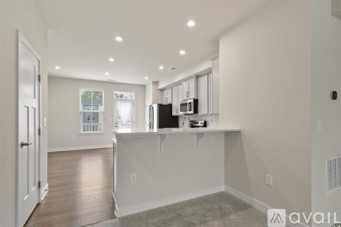 A spacious kitchen with white cabinets and a large island.