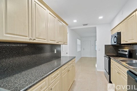 A kitchen with wooden cabinets and a black countertop.