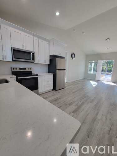 A kitchen with white cabinets and a marble countertop.