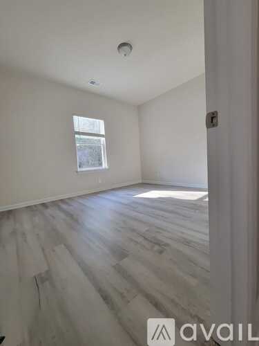 A room with wooden flooring and a window.