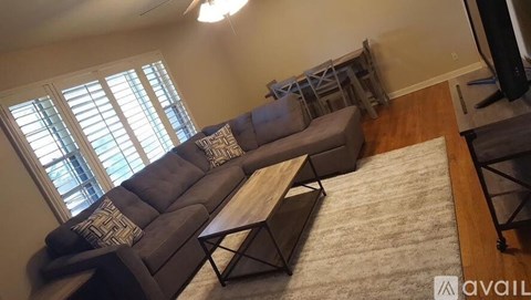 A living room with a grey sofa and a wooden coffee table.