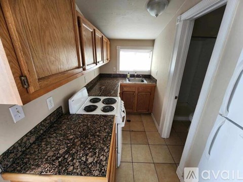 A kitchen with wooden cabinets and a granite countertop.