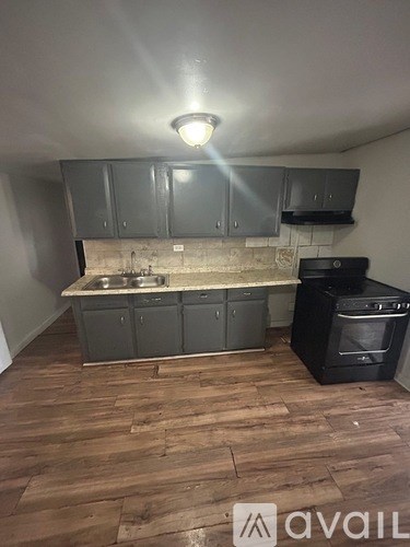 A kitchen with wooden floors and a black oven.