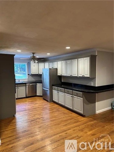 A kitchen with wooden floors and a ceiling fan.