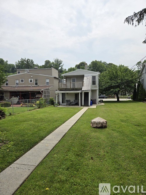 A house with a well-maintained lawn and a sidewalk in front.