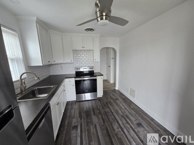 A kitchen with white cabinets and a stainless steel refrigerator.