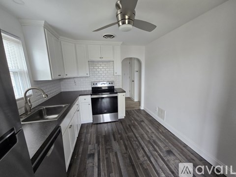A kitchen with white cabinets and a stainless steel refrigerator.