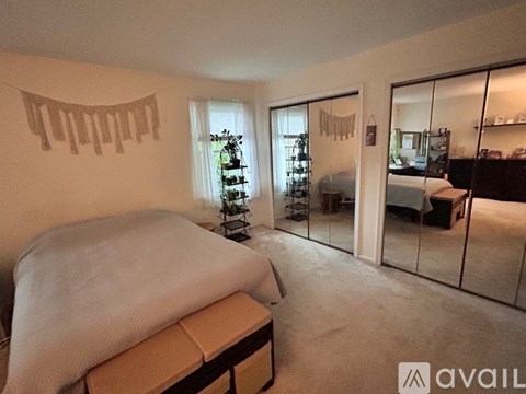 A bedroom with a bed and a mirrored wall.