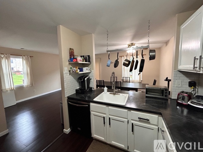 A kitchen with black countertops and white cabinets.