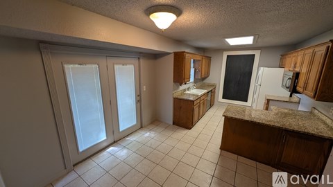 A kitchen with a counter, sink, and cabinets is available for rent.