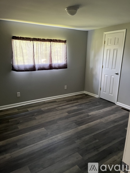 A room with a wooden floor and a white door.