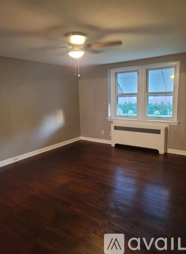 A room with a window and a fan on the ceiling.