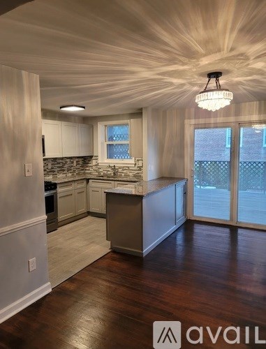A kitchen with wooden floors and a ceiling light.