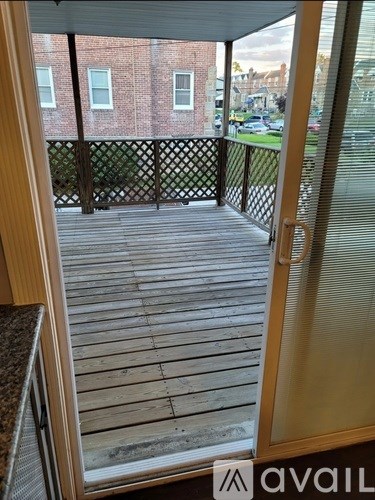 A balcony with a view of a brick building across the way.