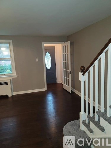 A hallway with a staircase and a window.