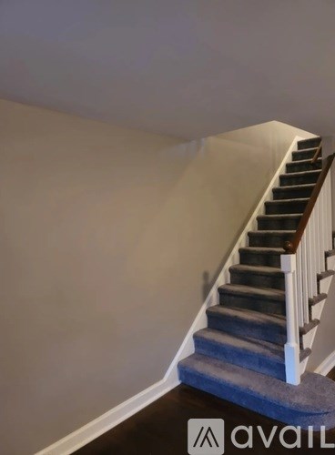 A staircase with a blue carpeted runner.
