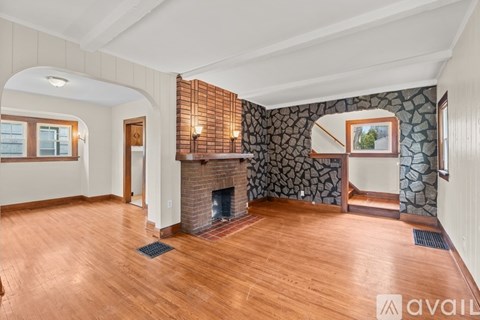 A living room with a stone wall and a fireplace.