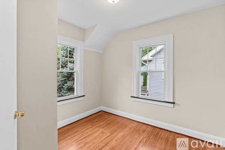 A room with a door and a window with a view of a house.