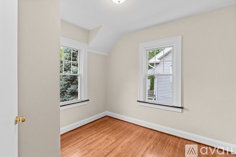 A room with a door and a window with a view of a house.