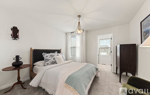 A bedroom with a large bed and a chandelier.